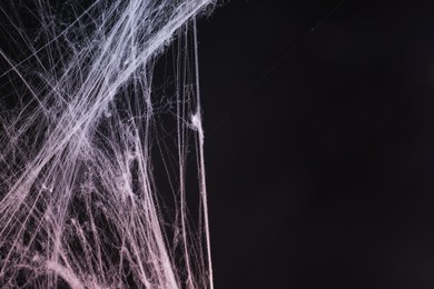 Image of Cobweb against black background, toned in gradient red color. Space for text