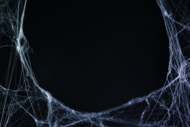 Image of Cobweb against black background, toned in gradient blue color. Space for text