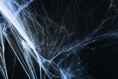 Image of Cobweb against black background, toned in gradient blue color