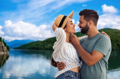 Happy newlyweds enjoying their honeymoon. Couple smiling near beautiful lake