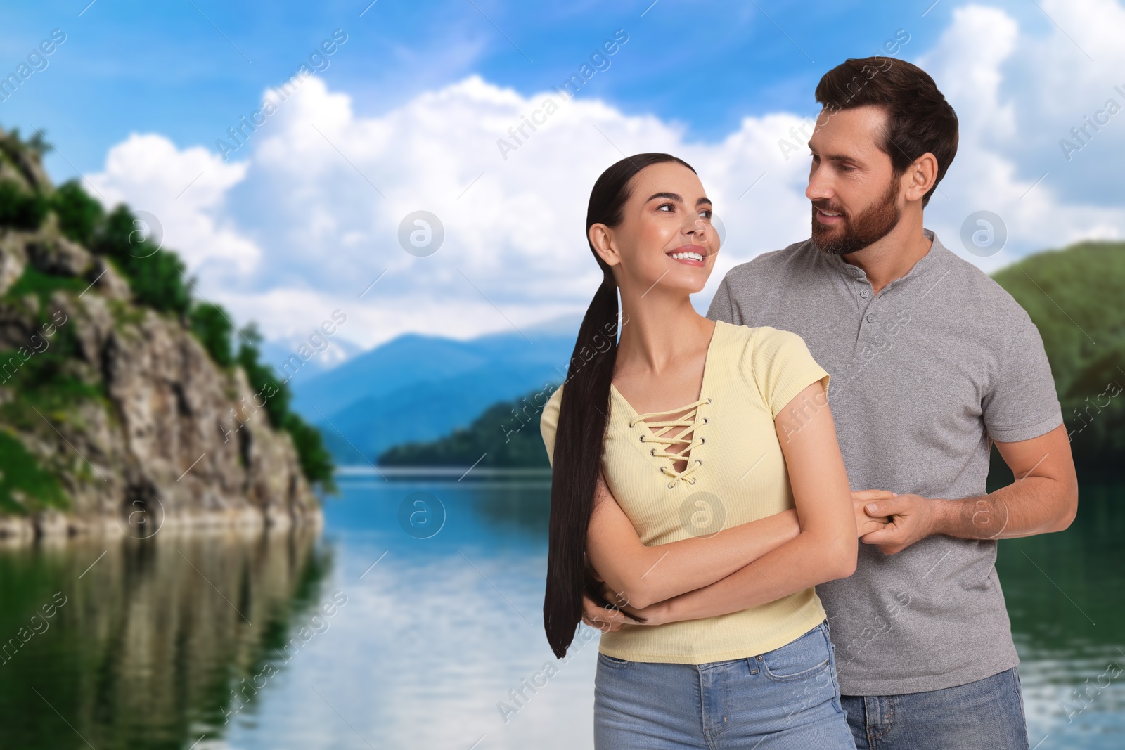 Image of Happy newlyweds enjoying their honeymoon. Couple smiling near beautiful lake