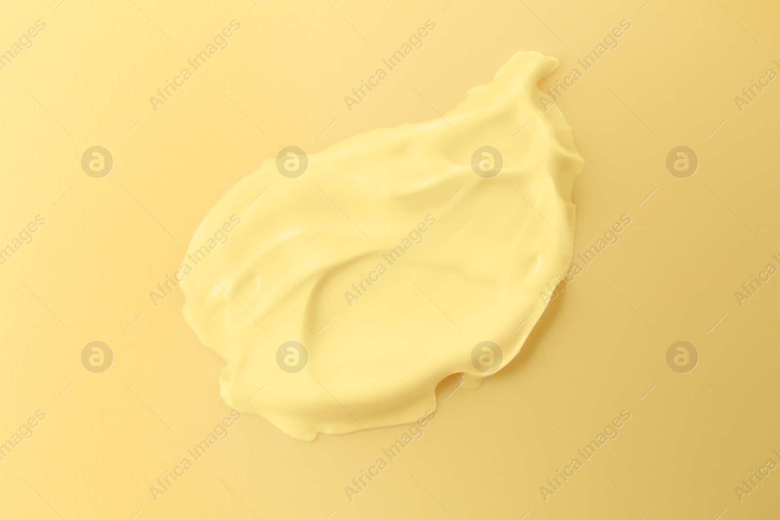 Image of Sample of face cream on yellow background, top view