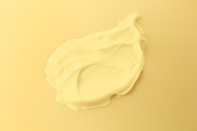 Image of Sample of face cream on yellow background, top view