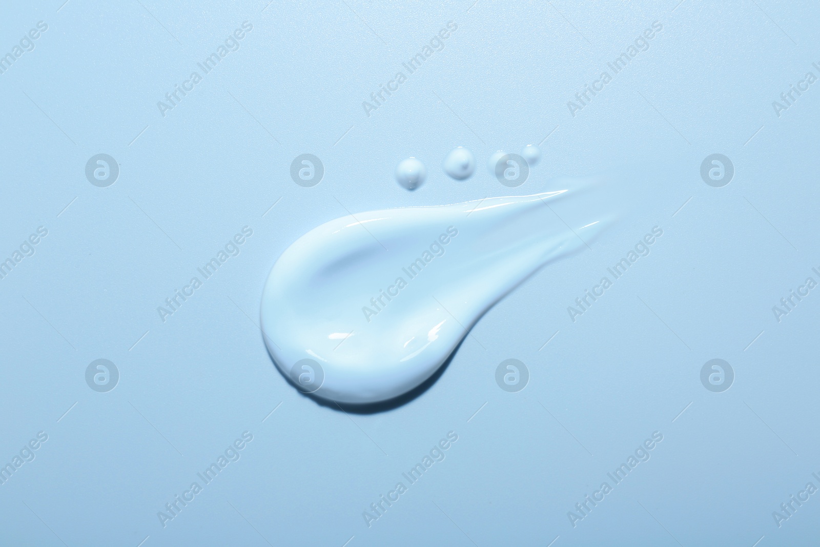 Image of Sample of face cream on light blue background, top view