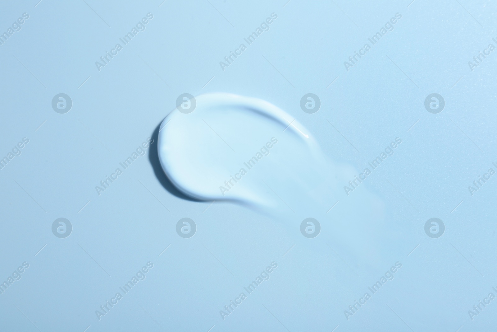 Image of Sample of face cream on light blue background, top view