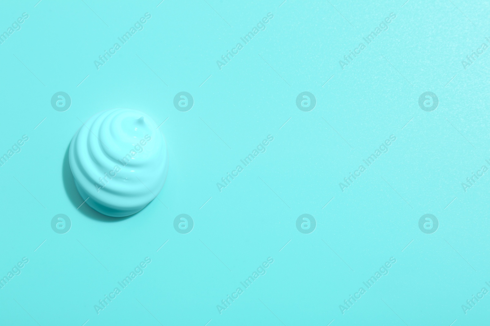 Image of Sample of face cream on turquoise background, top view. Space for text