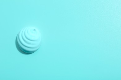 Image of Sample of face cream on turquoise background, top view. Space for text