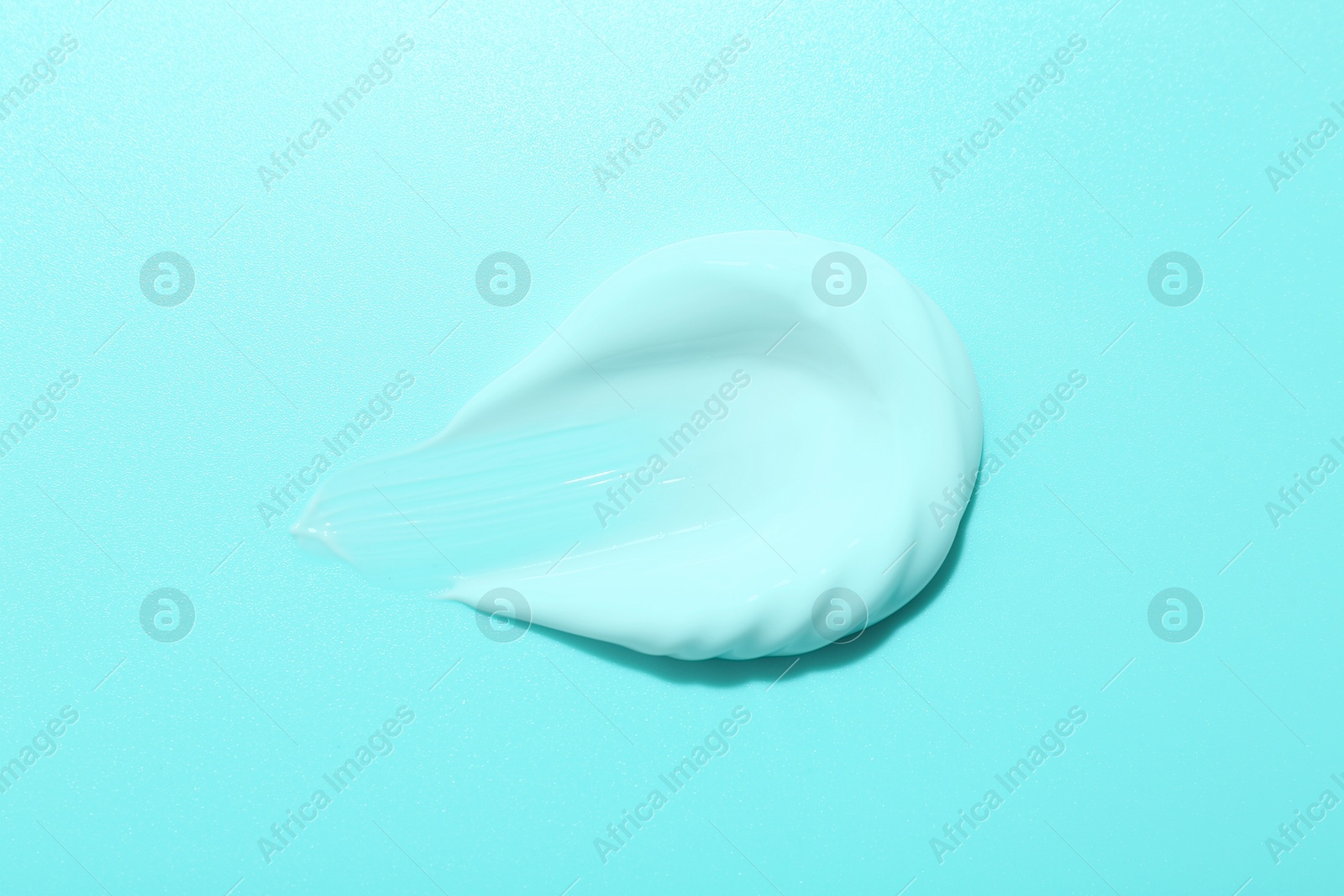 Image of Sample of face cream on turquoise background, top view