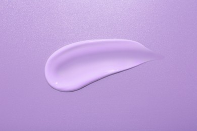 Image of Sample of face cream on violet background, top view