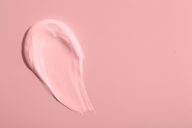 Image of Sample of face cream on pink background, top view. Space for text