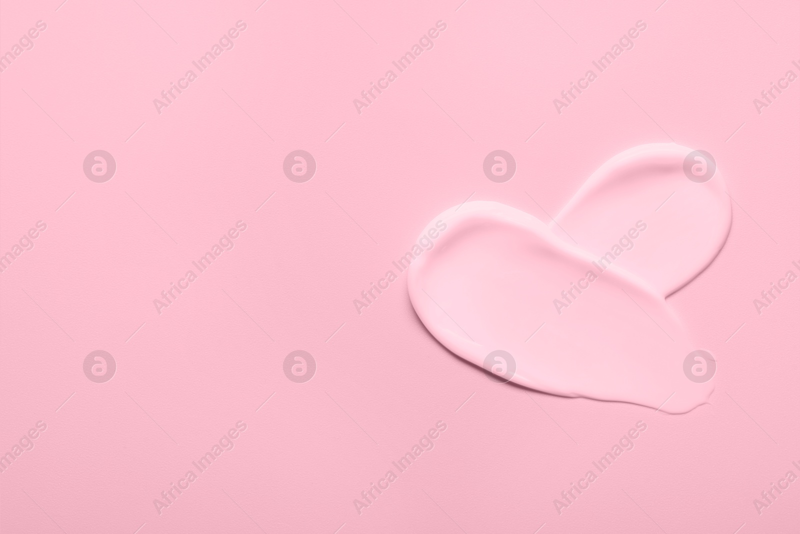 Image of Samples of face cream on pink background, top view. Space for text