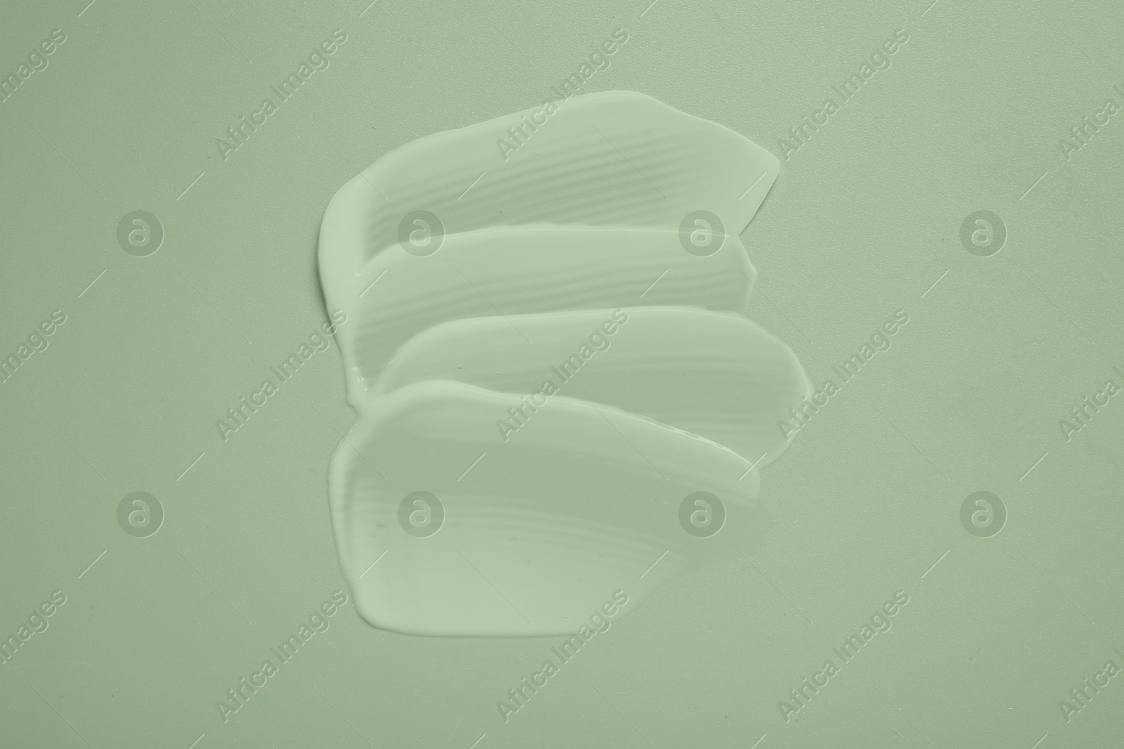 Image of Samples of face cream on pale green background, top view