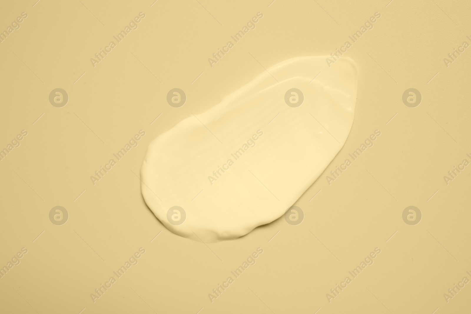 Image of Sample of face cream on beige background, top view