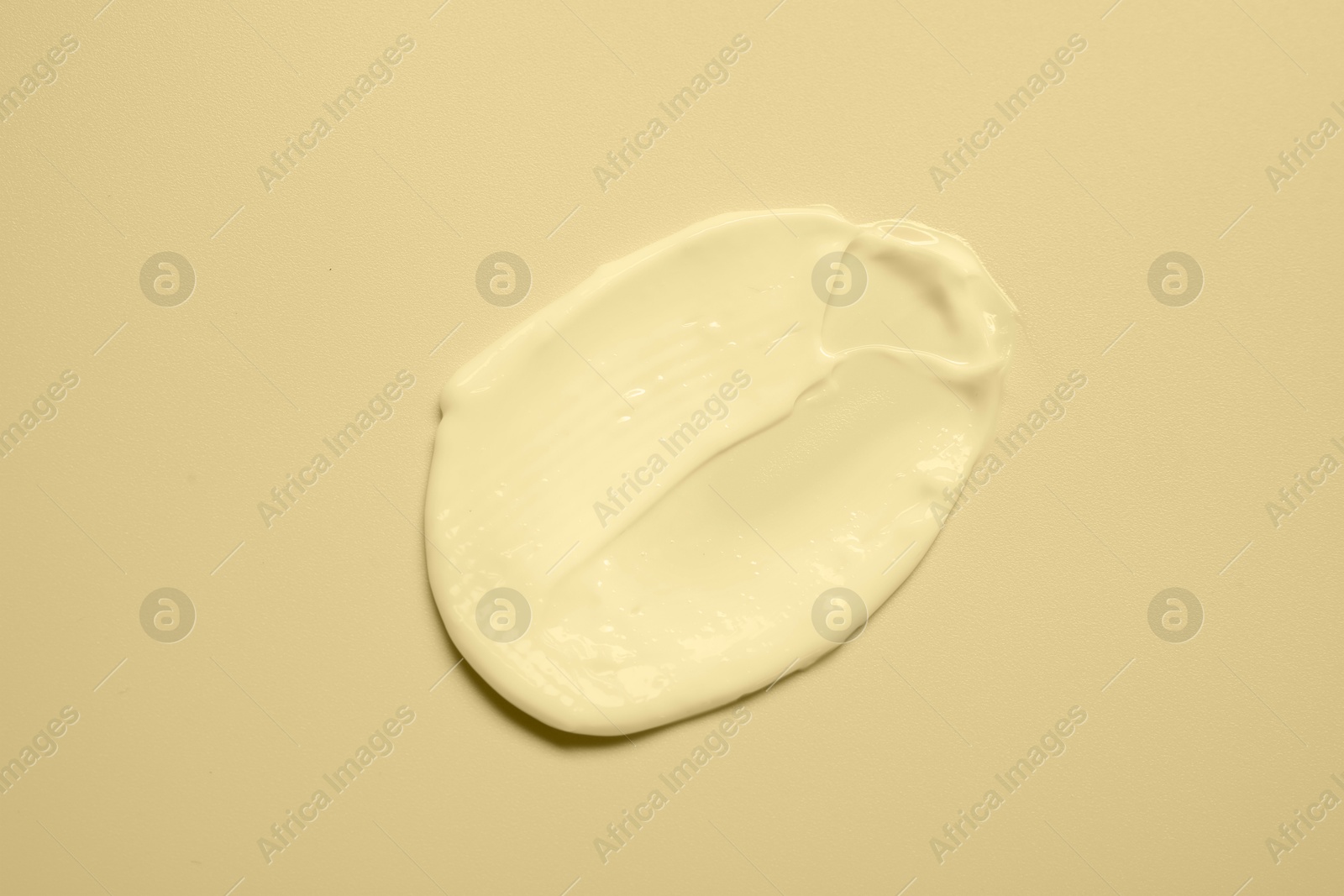 Image of Sample of face cream on beige background, top view