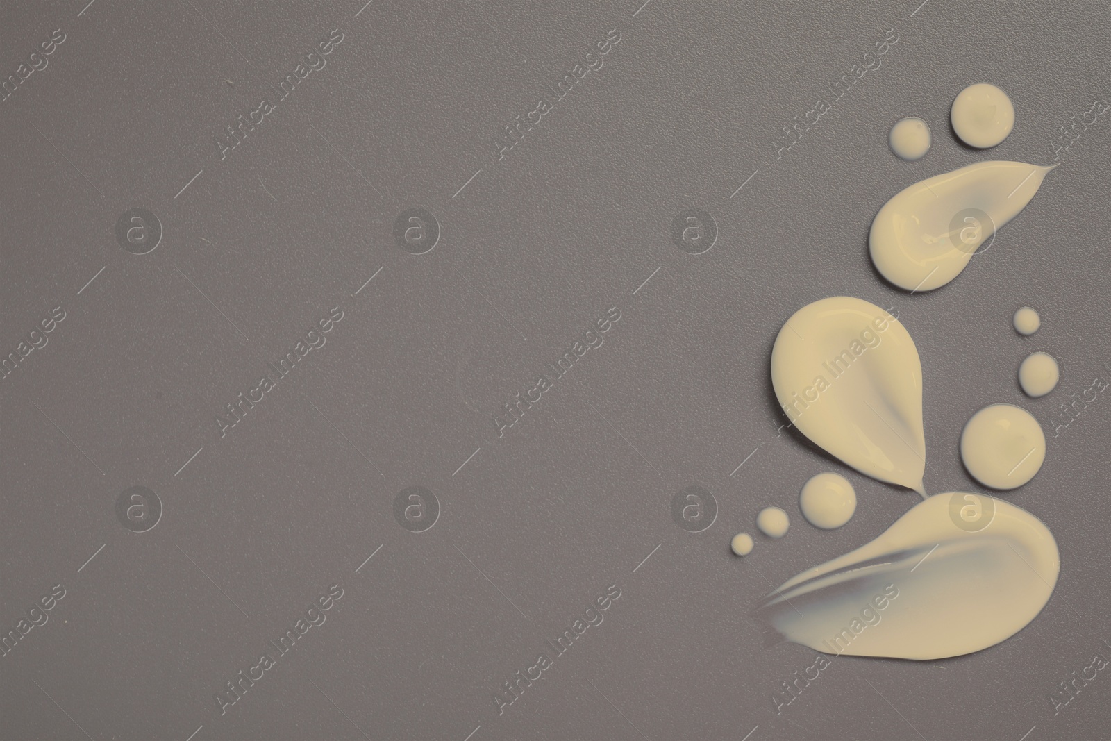 Image of Samples of beige face cream on grey background, flat lay. Space for text