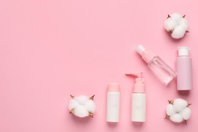 Photo of Different cosmetic products and cotton flowers on pink background, flat lay. Space for text