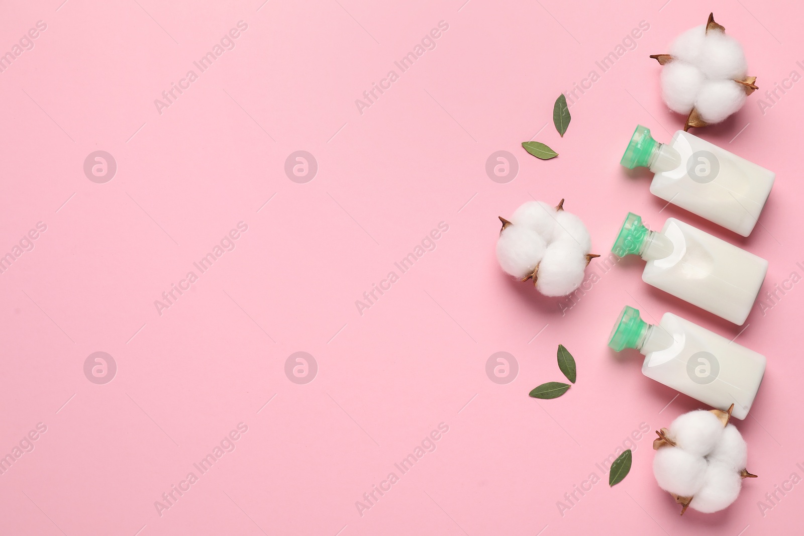 Photo of Different cosmetic products, leaves and cotton flowers on pink background, flat lay. Space for text