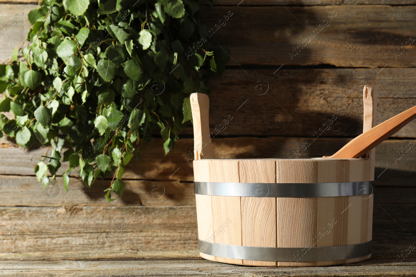 Photo of Sauna equipment. Bucket and ladle on wooden surface