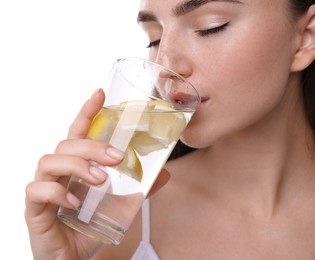 Photo of Woman drinking water with lemon on white background, closeup