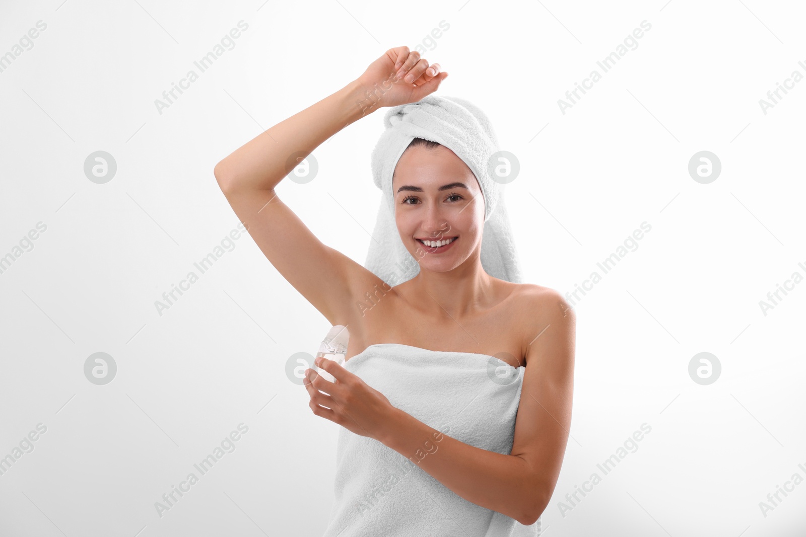 Photo of Smiling woman applying roll-on deodorant on white background