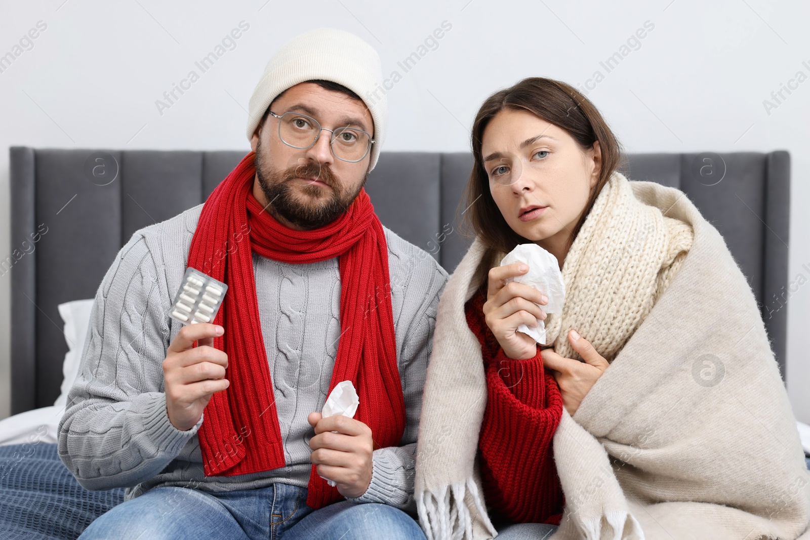 Photo of Cold symptom. Couple suffering from fever on bed at home