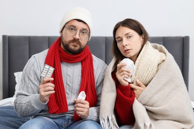 Photo of Cold symptom. Couple suffering from fever on bed at home