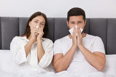 Photo of Cold symptom. Couple suffering from fever in bed at home