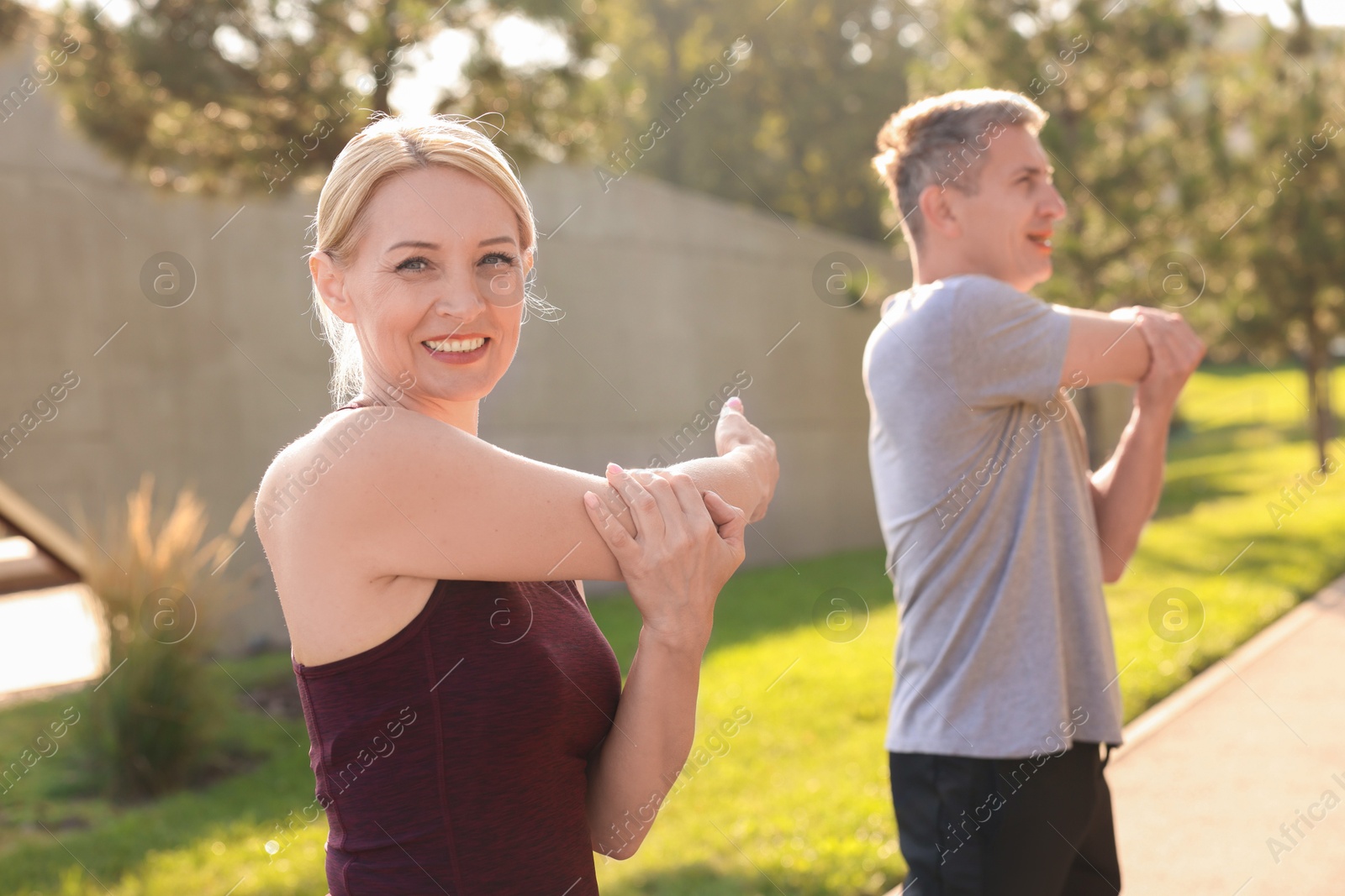 Photo of Happy couple doing exercises in park, selective focus