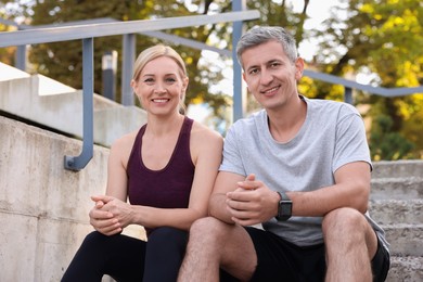 Photo of Portrait of smiling couple on steps outdoors