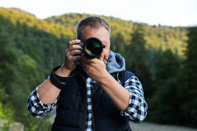 Photographer with backpack and camera in beautiful mountains