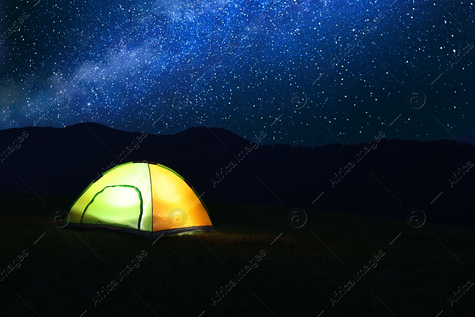 Photo of Modern camping tent in wilderness at night, space for text