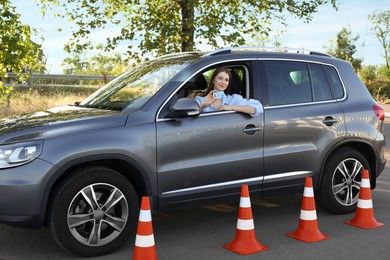 Photo of Driving school. Woman with driving license in car after exam