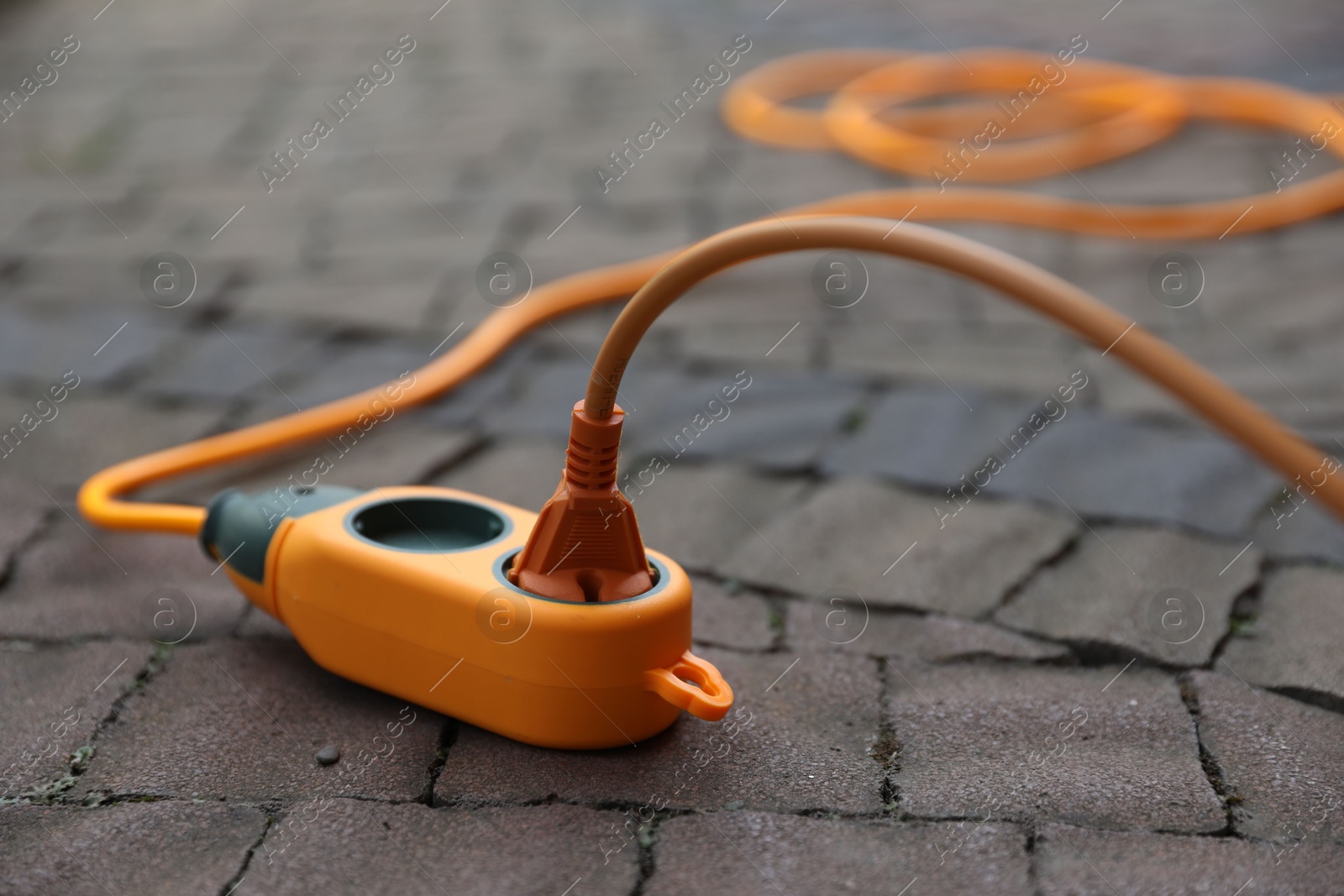 Photo of Extension cord on paved pathway outdoors, closeup