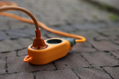 Photo of Extension cord on paved pathway outdoors, closeup