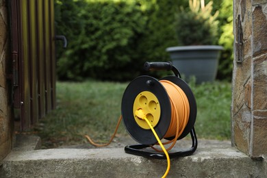 Photo of Extension cord reel in backyard. Electrician's equipment