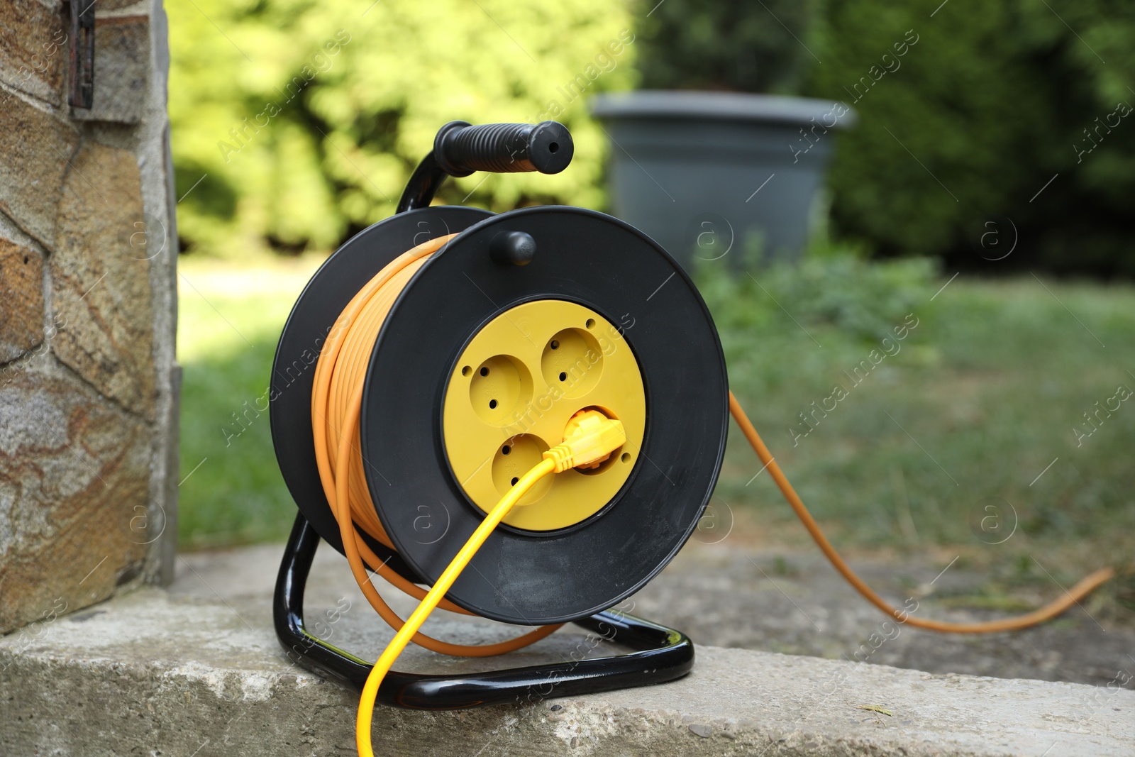 Photo of Extension cord reel in backyard. Electrician's equipment