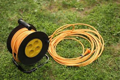 Photo of Extension cord reel on green grass outdoors