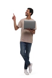 Photo of Smiling man with laptop pointing at something on white background