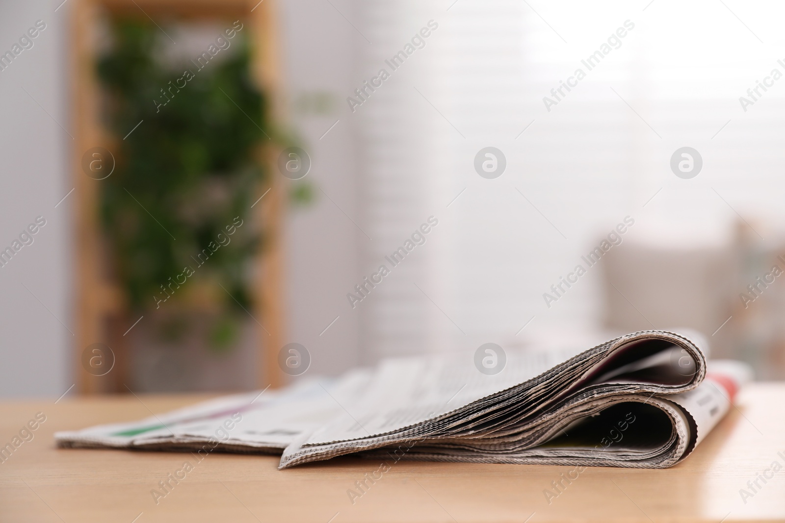 Photo of Stack of newspapers in different languages on table indoors