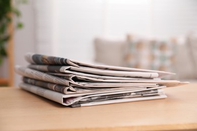 Photo of Stack of newspapers in different languages on table indoors