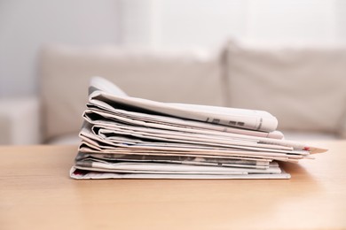 Photo of Stack of newspapers in different languages on table indoors