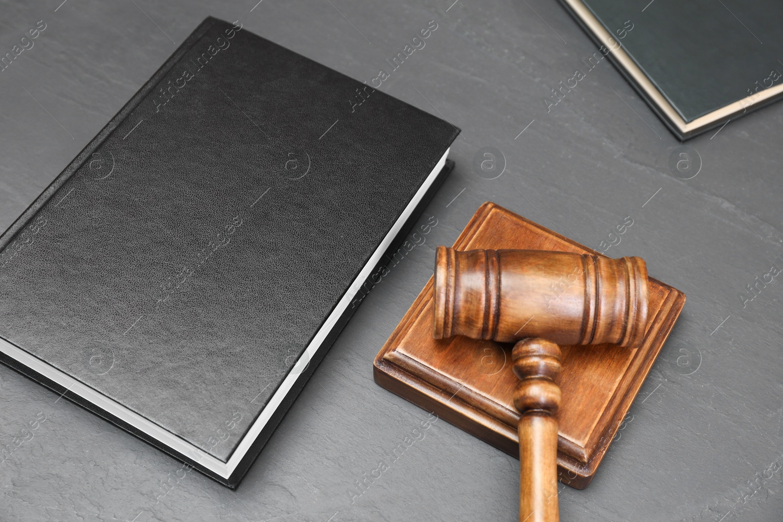 Photo of Book and judge's gavel on gray textured table