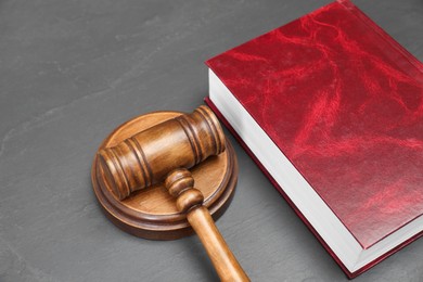 Book and judge's gavel on gray textured table