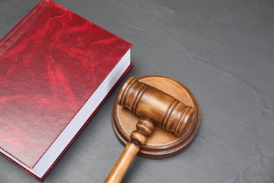 Photo of Book and judge's gavel on gray textured table