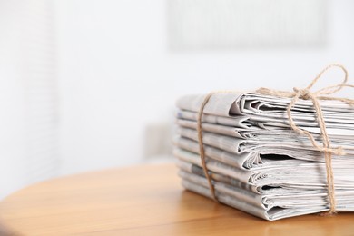 Photo of Stack of many newspapers on wooden table, space for text