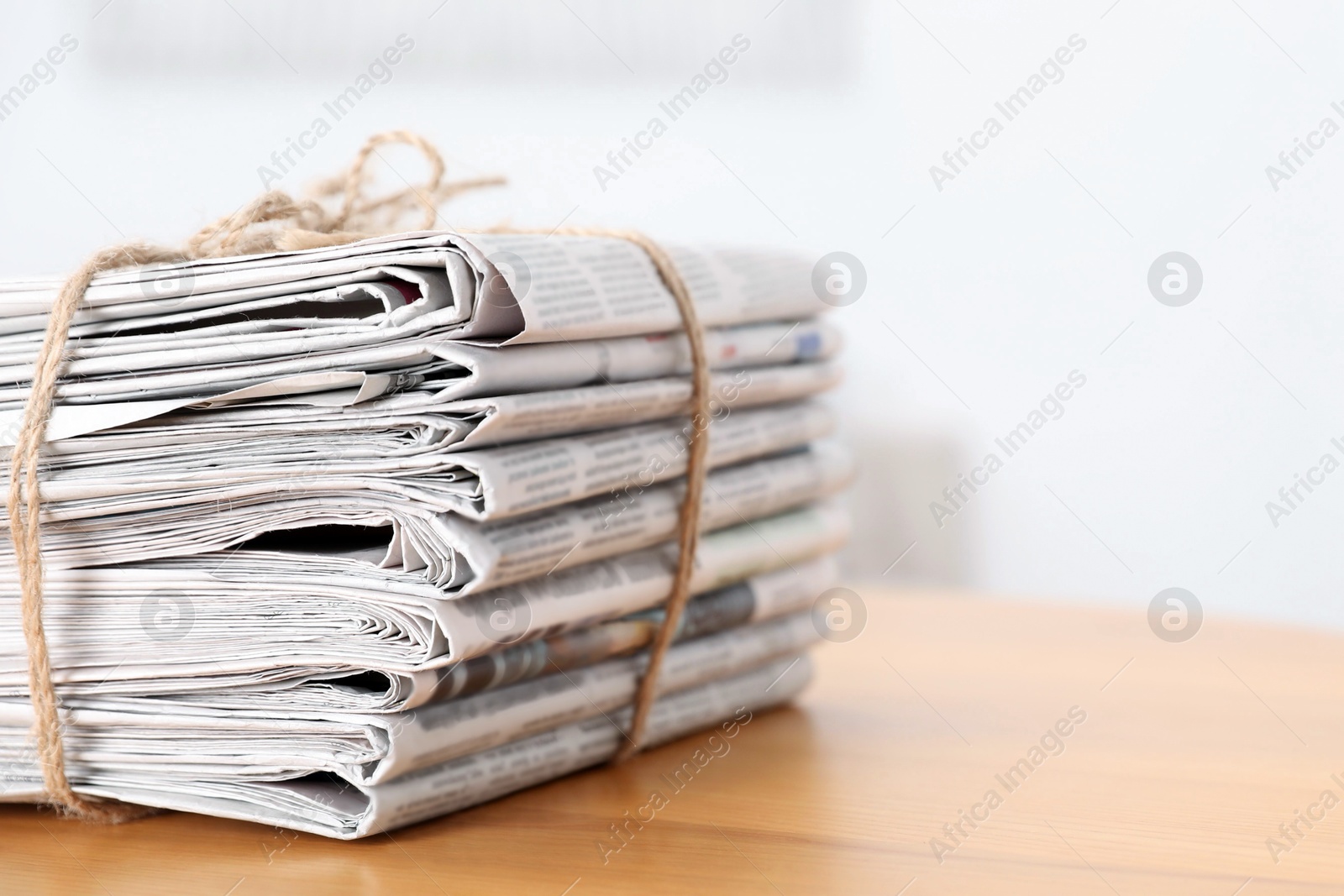 Photo of Stack of many newspapers on wooden table, space for text