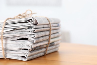 Photo of Stack of many newspapers on wooden table, space for text