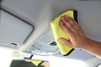 Man cleaning car interior with rag, closeup