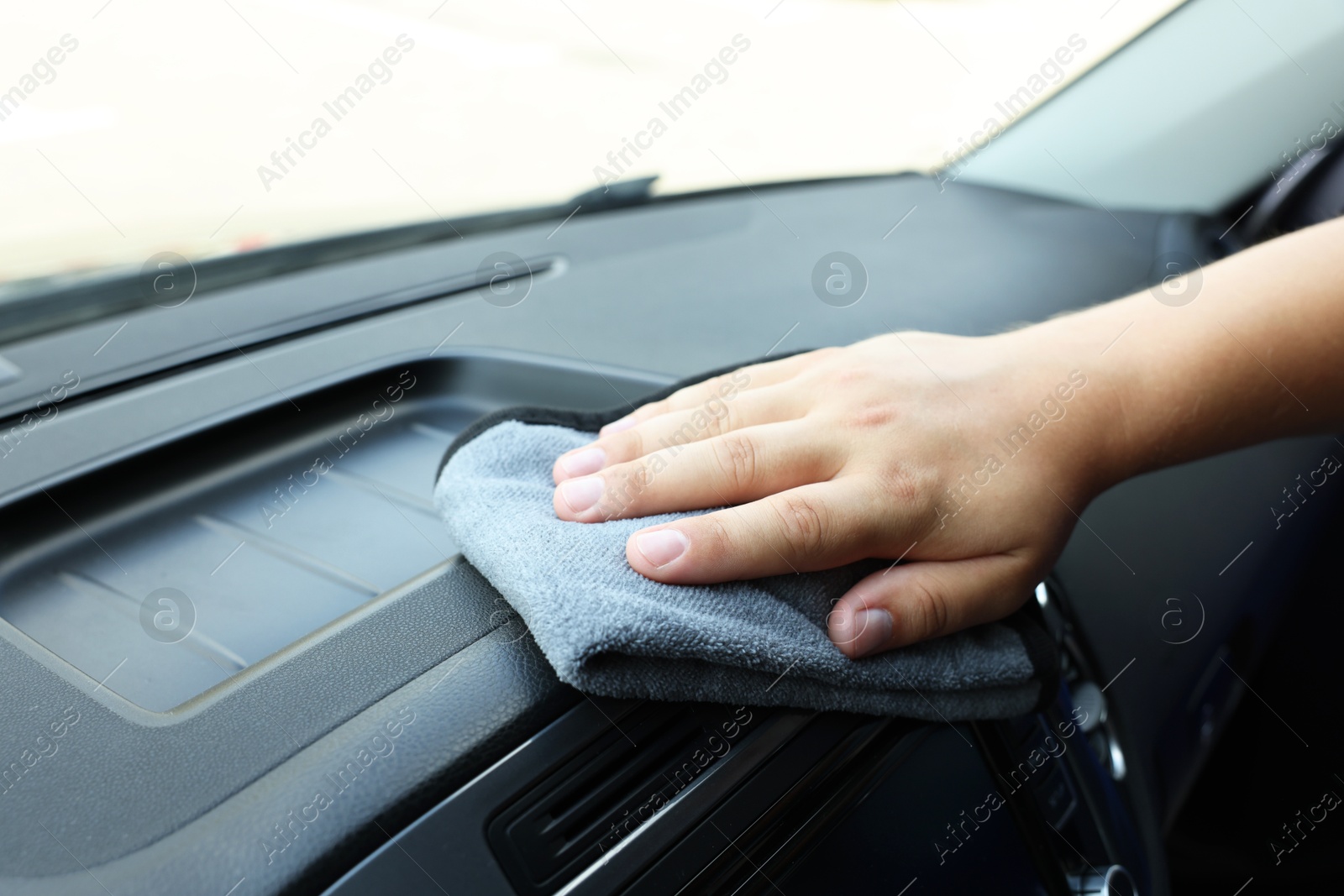 Photo of Man cleaning car interior with rag, closeup