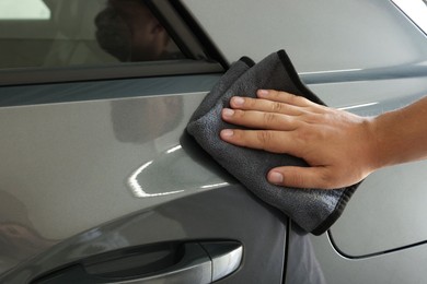 Photo of Man wiping auto with rag at car wash, closeup